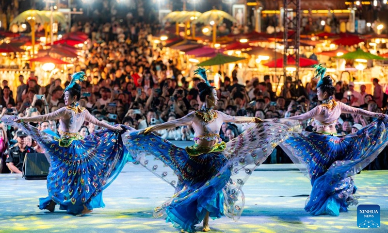 Tourists watch a performance at the Starlight Night Market in Jinghong City of Xishuangbanna Dai Autonomous Prefecture, southwest China's Yunnan Province, Dec. 7, 2024. The night market is a destination to experience the customs of Dai ethnic group. Photo: Xinhua