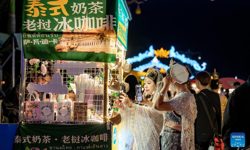 Tourists visit the Starlight Night Market in Jinghong City of Xishuangbanna Dai Autonomous Prefecture, southwest China's Yunnan Province, Dec. 7, 2024. The night market is a destination to experience the customs of Dai ethnic group. Photo: Xinhua