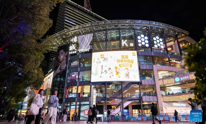 Tourists walk past a shopping mall in Kunming City, southwest China's Yunnan Province, Dec. 6, 2024. In recent years, Kunming has stepped up its efforts to enrich citizen's life by developing night fair compounds. Photo: Xinhua