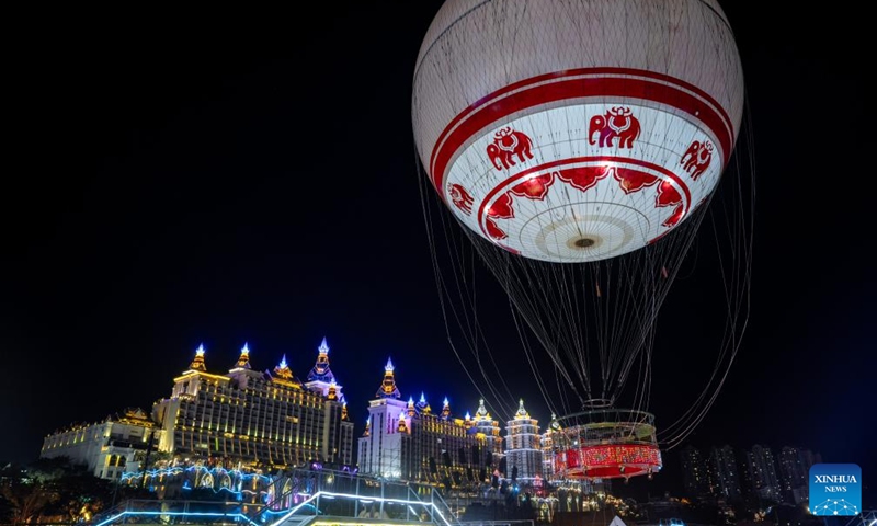 Tourists take a ride on a hot air balloon at the Starlight Night Market in Jinghong City of Xishuangbanna Dai Autonomous Prefecture, southwest China's Yunnan Province, Dec. 7, 2024. The night market is a destination to experience the customs of Dai ethnic group. Photo: Xinhua