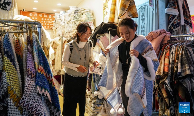 Tourists select clothes on a street at night in Kunming City, southwest China's Yunnan Province, Dec. 6, 2024. In recent years, Kunming has stepped up its efforts to enrich citizen's life by developing night fair compounds. Photo: Xinhua