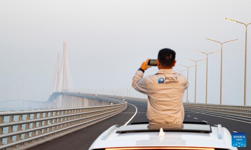 A construction worker takes photos on the Huangmao Sea Channel Bridge in south China's Guangdong Province, Dec. 7, 2024. The bridge is scheduled to open to traffic in December. Photo: Xinhua