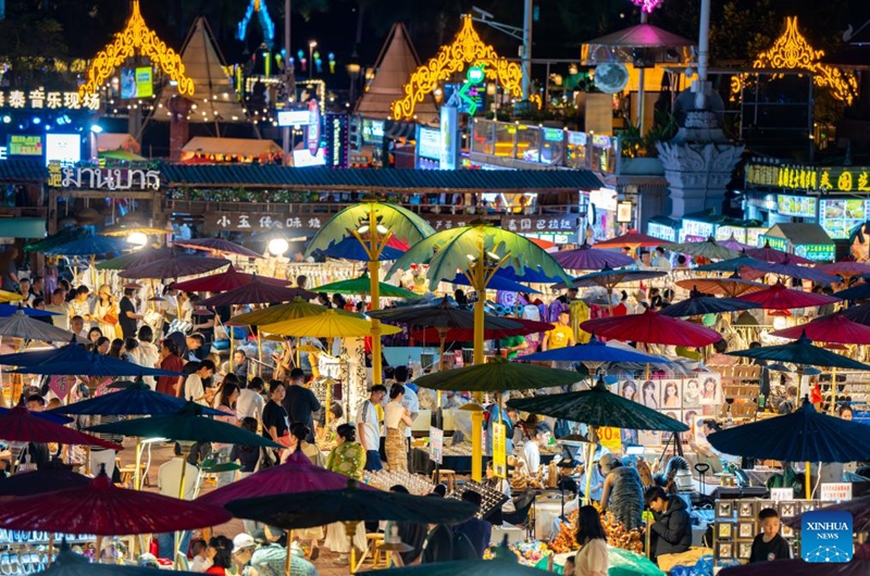 Tourists visit the Starlight Night Market in Jinghong City of Xishuangbanna Dai Autonomous Prefecture, southwest China's Yunnan Province, Dec. 7, 2024. The night market is a destination to experience the customs of Dai ethnic group. Photo: Xinhua