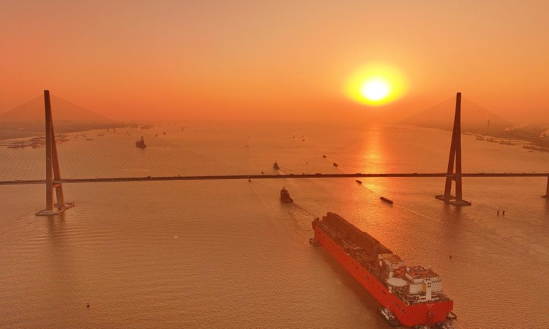 This aerial drone photo taken on Dec. 9, 2024 shows the NGUYA FLNG, a floating liquified natural gas (FLNG) facility, being tugged through the Sutong (Suzhou-Nantong) Bridge across the Yangtze River in east China's Jiangsu Province. (Photo: Xinhua)