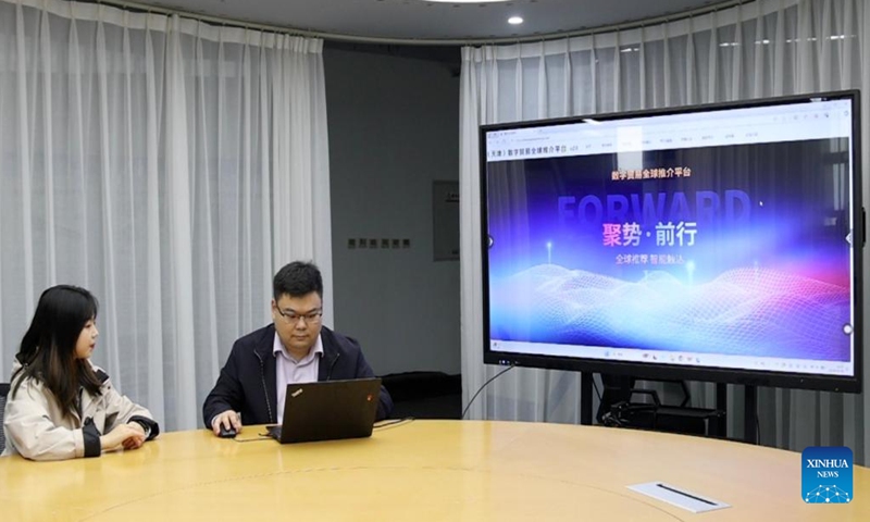 Li Huarong (R), an account director at the BlueFocus (Tianjin) Digital Service Industry Promotion Center, showcases the Tianjin Digital Trade Global Promotion Platform on a screen in north China's Tianjin Municipality, Nov. 15, 2024. (Photo: Xinhua)