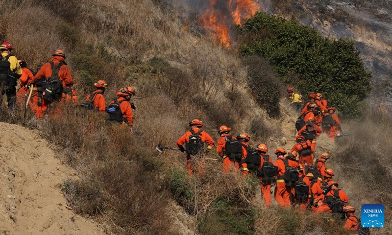 Firefighters try to contain the wildfire on a hill in Malibu, California, the United States, Dec. 10, 2024. (Photo: ecns.cn)