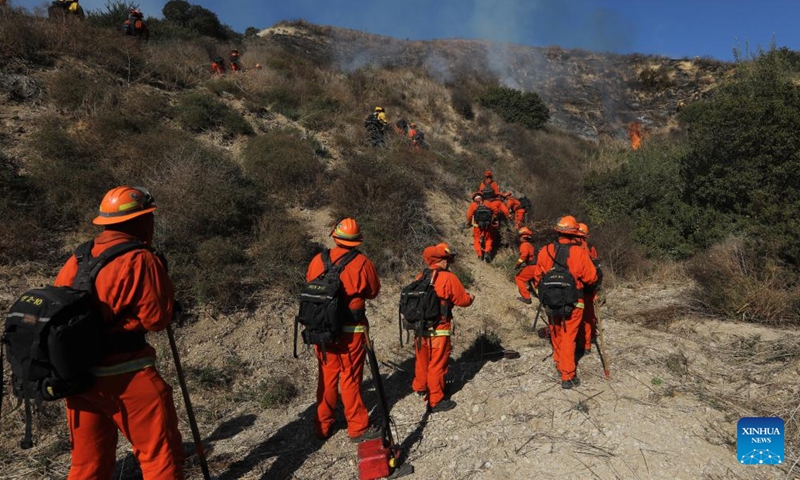 Firefighters try to contain the wildfire on a hill in Malibu, California, the United States, Dec. 10, 2024. (Photo: ecns.cn)