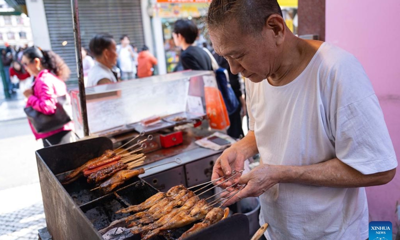 A roast shop worker prepares kebab in Macao, south China, Dec. 8, 2024. (Photo: Xinhua)