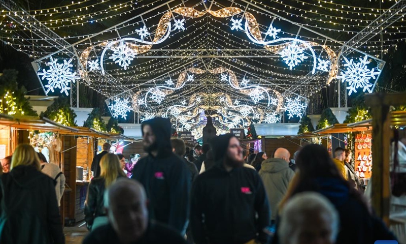 People walk under light decorations at a Christmas fairyland in Valletta, Malta, on Dec. 10, 2024. (Photo: Xinhua)