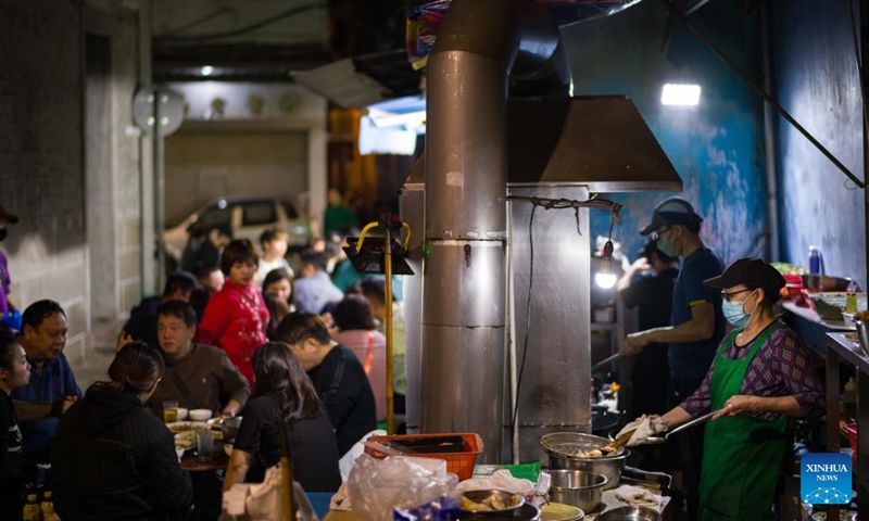 Workers cook at a Dai Pai Dong street food stall in Macao, south China, Dec. 8, 2024. (Photo: Xinhua)