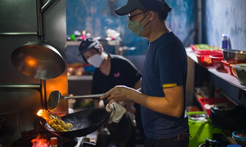 A worker cooks at a Dai Pai Dong street food stall in Macao, south China, Dec. 8, 2024. (Photo: Xinhua)