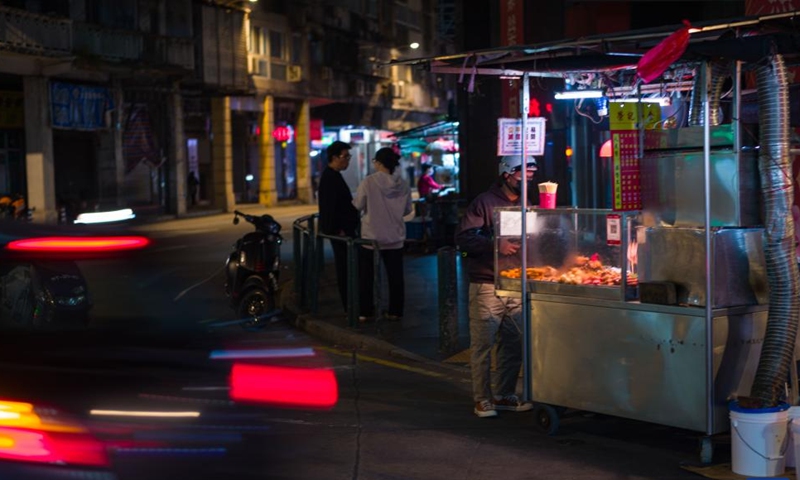 A food stall worker packs snacks for a customer in Macao, south China, Dec. 9, 2024. (Photo: Xinhua)