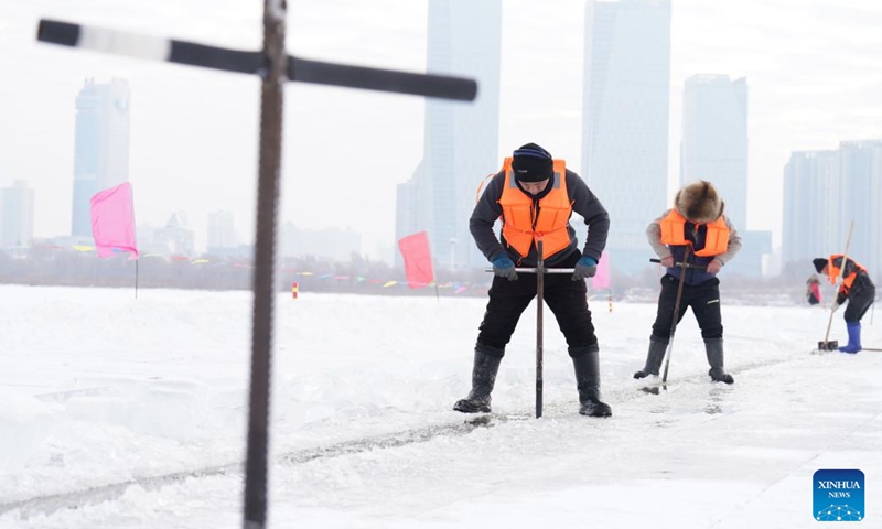 Laborers collect ice cubes at the construction site of the Harbin Ice-Snow World in Harbin, northeast China's Heilongjiang Province, Dec. 9, 2024. (Photo: Xinhua)