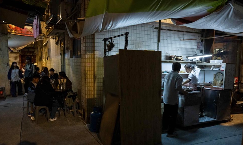 Workers cook clay pot rice at a food stall in Macao, south China, Dec. 8, 2024. (Photo: Xinhua)