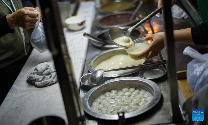 A food stall worker packs sweet for customers in Macao, south China, Dec. 8, 2024. (Photo: Xinhua)