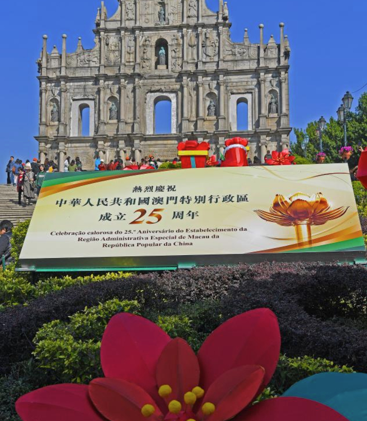 A celebration poster is seen in front of the Ruins of St. Paul's in Macao, south China, Dec. 17, 2024. The streets of Macao have been adorned by festive decorations, as the city is set to mark the 25th anniversary of its return to the motherland. (Xinhua/Chen Duo)