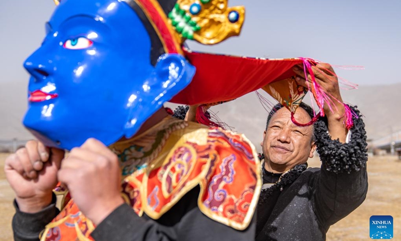 Shilok (R) and his colleague check a traditional Tibetan mask in Dagze District of Lhasa, southwest China's Xizang Autonomous Region, Dec. 9, 2024. Shilok is an inheritor of a traditional Tibetan mask making technique, a regional intangible cultural heritage with time-consuming procedures including sculpting, layering, air-drying, and painting.(Photo: Xinhua)