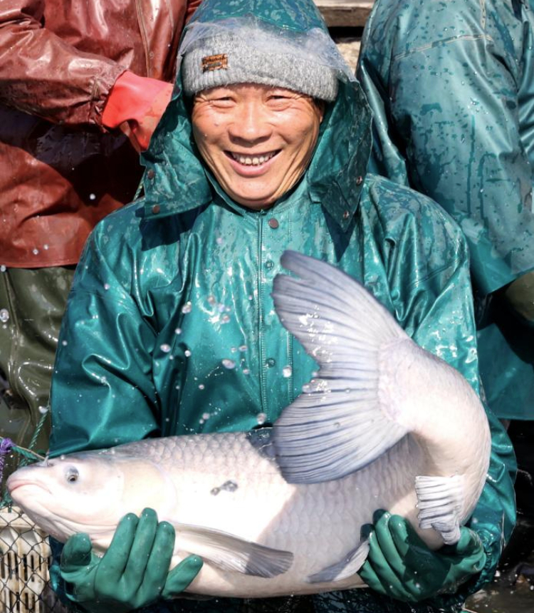 A villager shows a fish caught in Dongheng Village of Luoshe Town, Deqing County, Huzhou City, east China's Zhejiang Province, Dec. 17, 2024. Villagers here are taking advantage of the ongoing winter fishing season to supply the market with fresh fish harvests. (Photo by Xie Shangguo/Xinhua)