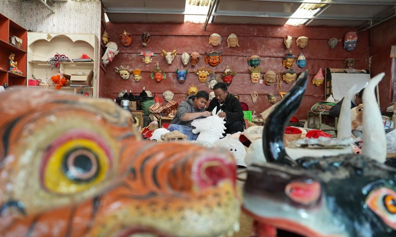 Shilok (R) and his colleague talk about traditional Tibetan mask-making experience in Lhasa, southwest China's Xizang Autonomous Region, Dec. 9, 2024. (Photo: Xinhua)