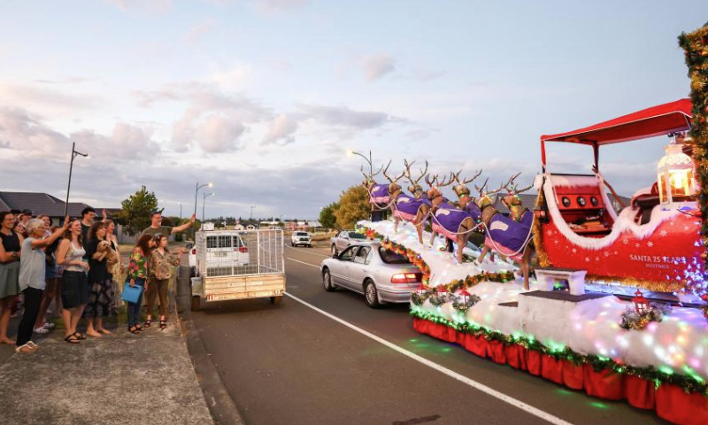 Residents look at a trailer with Christmas decoration in Hastings, New Zealand, Dec. 22, 2024. (Photo by Long Lei/Xinhua)