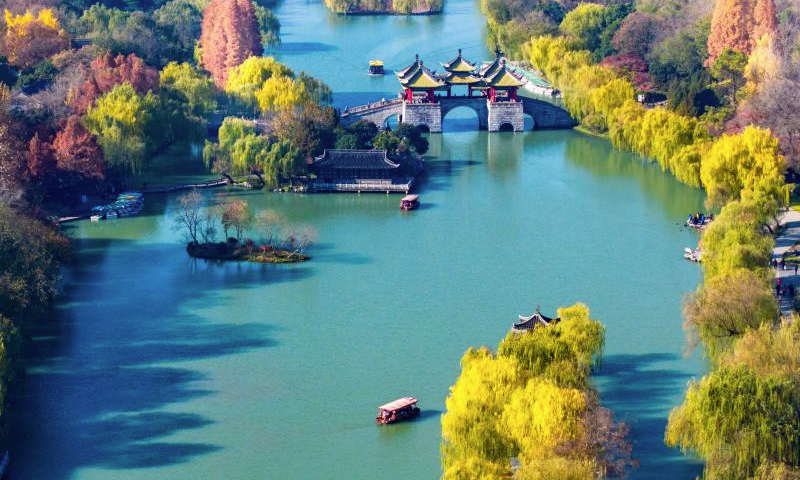 An aerial drone photo taken on Dec. 16, 2024 shows tourists visiting the Slender West Lake scenic spot in Yangzhou, east China's Jiangsu Province. (Photo by Zhou Shegen/Xinhua)