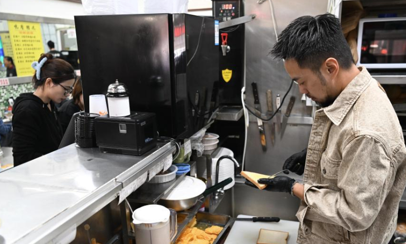 Iao Chi Fai makes a sandwich at his restaurant in Zhuhai, south China's Guangdong Province, Dec. 13, 2024. Iao Chi Fai, a young man from Macao, opened a restaurant in Zhuhai with his business partners in 2016. He hopes to promote Macao's food culture to the mainland.

Iao combines Macao's cooking characteristics with the dining habits of mainland customers, and has introduced many creative dishes.

Currently, Iao and his business partners run eight restaurants in the Guangdong-Hong Kong-Macao Greater Bay Area (GBA). He looks forward to expanding his business on the mainland and building the restaurant into a time-honored brand featuring delicious dishes and high-quality service. (Xinhua/Deng Hua)