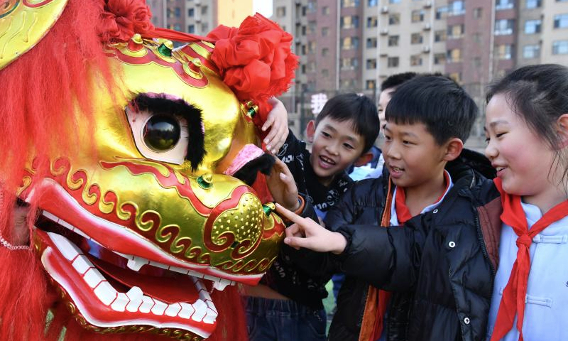 Students interact with a lion dancer from Cangxian County at a primary school in Cangzhou City, north China's Hebei Province, Dec. 20, 2024. Cangxian Lion Dance is a unique folk art with a long history, which was inscribed into the national intangible cultural heritage list in 2008. Thanks to the policy and funding support of local authorities in recent years, the traditional art has been well passed on. There are nine registered lion dance teams and nearly 1,000 performers in the county. (Xinhua/Mu Yu)