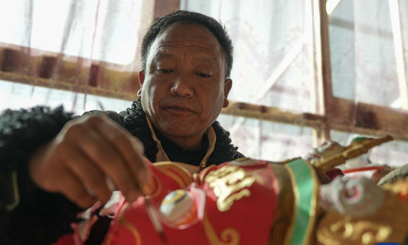 Shilok crafts a traditional Tibetan mask at a cooperative in Dagze District of Lhasa, southwest China's Xizang Autonomous Region, Dec. 9, 2024. (Photo: Xinhua)