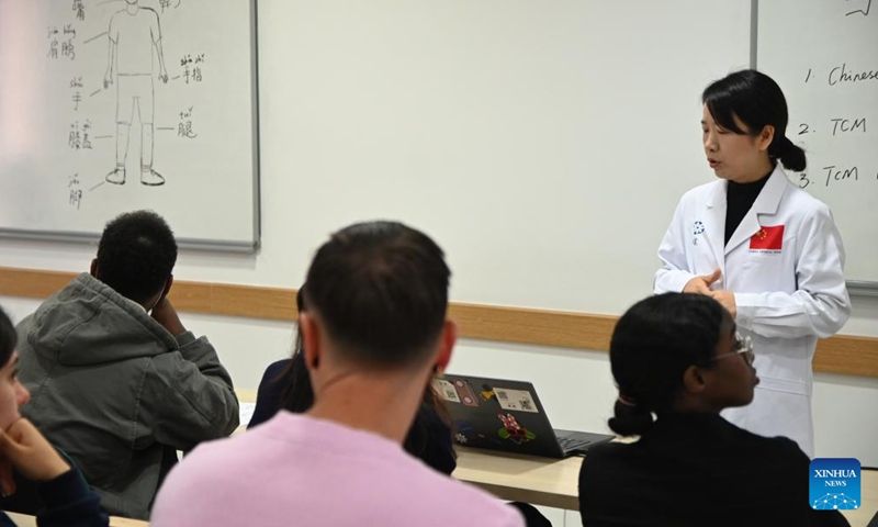 Tang Limei (Rear), a member of the 20th Chinese medical team for Malta, gives a lecture on traditional Chinese medicine at the University of Malta in Msida, Malta, on Dec. 11, 2024.  (Photo: Xinhua)