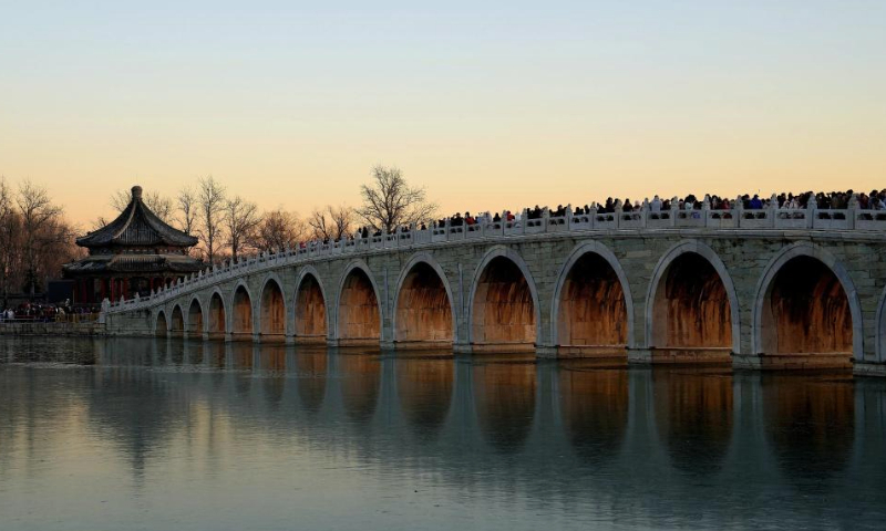 People visit the 17-Arch Bridge in the Summer Palace in Beijing, capital of China on Dec. 22, 2024. (Xinhua/Xing Guangli)