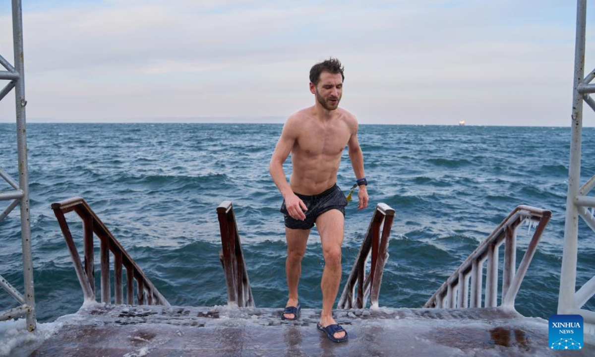 A man walks ashore after swimming in Vladivostok, Russia, Dec. 21, 2024. Vladivostok held a winter swimming festival on Saturday and attracted many local residents and tourists to participate. (Photo：Xinhua)