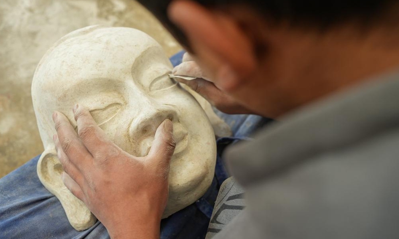 A craftsman makes a traditional Tibetan mask at a cooperative in Dagze District of Lhasa, southwest China's Xizang Autonomous Region, Dec. 9, 2024. (Photo: Xinhua)