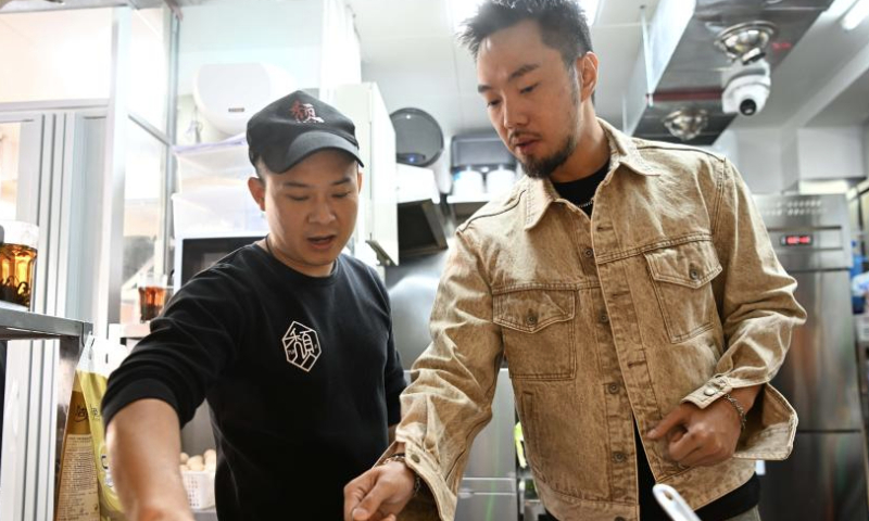 Iao Chi Fai (R) checks the sauce for cooking at his restaurant in Zhuhai, south China's Guangdong Province, Dec. 13, 2024. Iao Chi Fai, a young man from Macao, opened a restaurant in Zhuhai with his business partners in 2016. He hopes to promote Macao's food culture to the mainland.

Iao combines Macao's cooking characteristics with the dining habits of mainland customers, and has introduced many creative dishes.

Currently, Iao and his business partners run eight restaurants in the Guangdong-Hong Kong-Macao Greater Bay Area (GBA). He looks forward to expanding his business on the mainland and building the restaurant into a time-honored brand featuring delicious dishes and high-quality service. (Xinhua/Deng Hua)