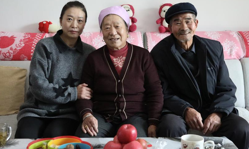 Villager Song Yonghong (1st L) and her family pose for a photo at their new home in a resettlement area in Dahejia Township of Jishishan County, northwest China's Gansu Province, Dec. 12, 2024. (Xinhua/Ma Sha)