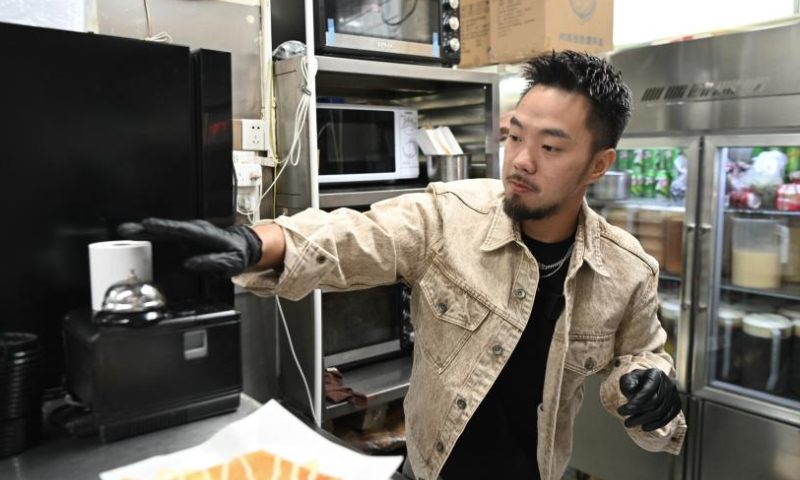 Iao Chi Fai prepares food at his restaurant in Zhuhai, south China's Guangdong Province, Dec. 13, 2024. Iao Chi Fai, a young man from Macao, opened a restaurant in Zhuhai with his business partners in 2016. He hopes to promote Macao's food culture to the mainland.

Iao combines Macao's cooking characteristics with the dining habits of mainland customers, and has introduced many creative dishes.

Currently, Iao and his business partners run eight restaurants in the Guangdong-Hong Kong-Macao Greater Bay Area (GBA). He looks forward to expanding his business on the mainland and building the restaurant into a time-honored brand featuring delicious dishes and high-quality service. (Xinhua/Deng Hua)