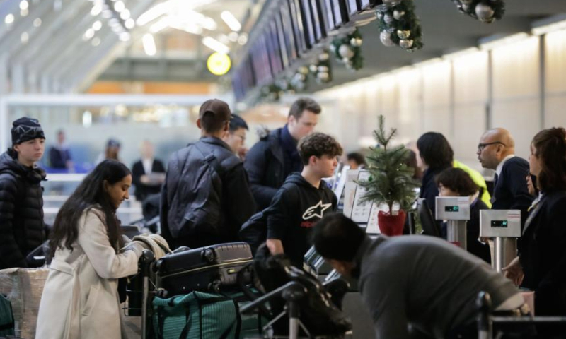 Travelers line up at an airline's check-in counter at Vancouver International Airport in Richmond, British Columbia, Canada, Dec. 21, 2024. With Christmas just around the corner, Vancouver International Airport is preparing for its busiest travel season. (Photo by Liang Sen/Xinhua)