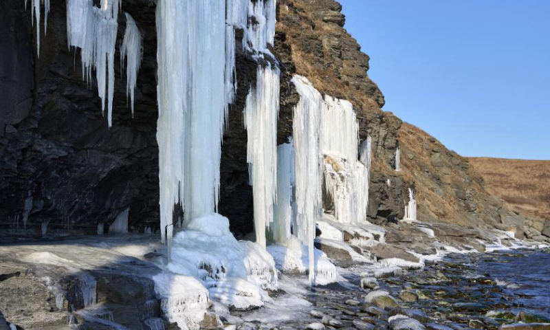 This photo taken on Dec. 18, 2024 shows icefalls by the sea in Vladivostok, Russia. As the temperature continues to drop in winter, massive icefalls are formed on the seashore of Vladivostok. (Photo by Guo Feizhou/Xinhua)