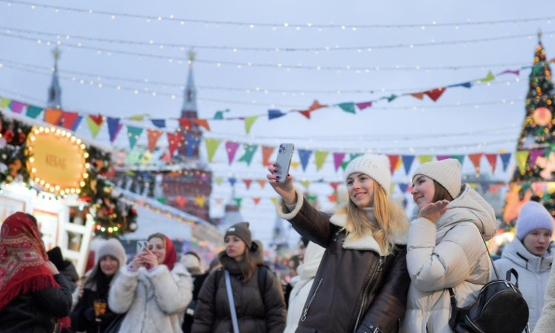 People pose for a selfie with New Year decorations at Red Square in Moscow, Russia, on Dec. 14, 2024. (Photo by Alexander Zemlianichenko Jr/Xinhua)