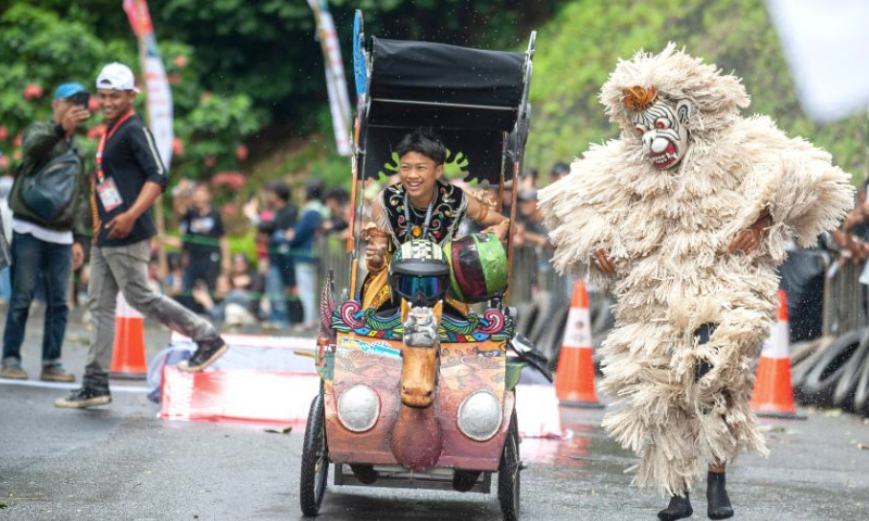 A participant drives a home-made vehicle without the engine in fun race category during the Bandung SoapBox Race 2024 in Bandung, West Java, Indonesia, Dec. 15, 2024. (Photo by Septianjar Muharam/Xinhua)