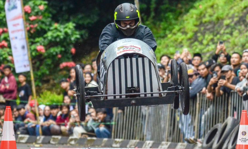 A participant drives a home-made vehicle without the engine in fun race category during the Bandung SoapBox Race 2024 in Bandung, West Java, Indonesia, Dec. 15, 2024. (Photo by Septianjar Muharam/Xinhua)