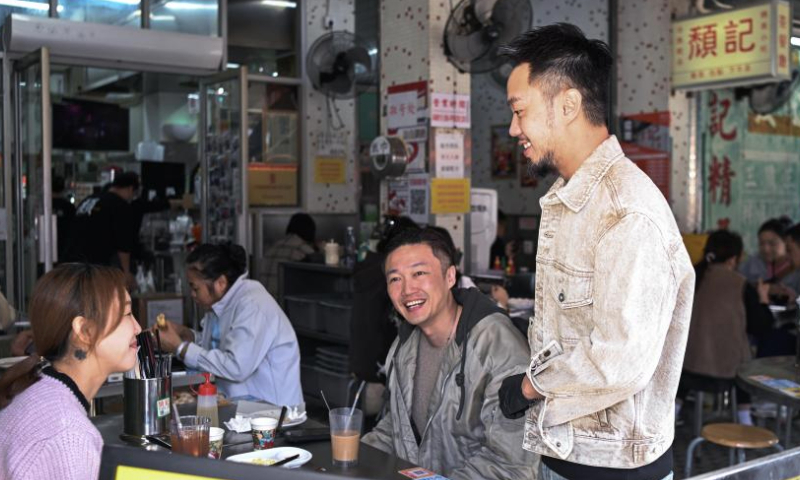 Iao Chi Fai (R) chats with customers at his restaurant in Zhuhai, south China's Guangdong Province, Dec. 13, 2024. Iao Chi Fai, a young man from Macao, opened a restaurant in Zhuhai with his business partners in 2016. He hopes to promote Macao's food culture to the mainland.

Iao combines Macao's cooking characteristics with the dining habits of mainland customers, and has introduced many creative dishes.

Currently, Iao and his business partners run eight restaurants in the Guangdong-Hong Kong-Macao Greater Bay Area (GBA). He looks forward to expanding his business on the mainland and building the restaurant into a time-honored brand featuring delicious dishes and high-quality service. (Xinhua/Deng Hua)