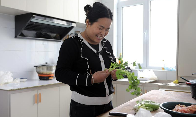 Villager Gong Shunlian prepares a meal in a resettlement area in Liuji Township of Jishishan County, northwest China's Gansu Province, Dec. 11, 2024. (Xinhua/Ma Sha)