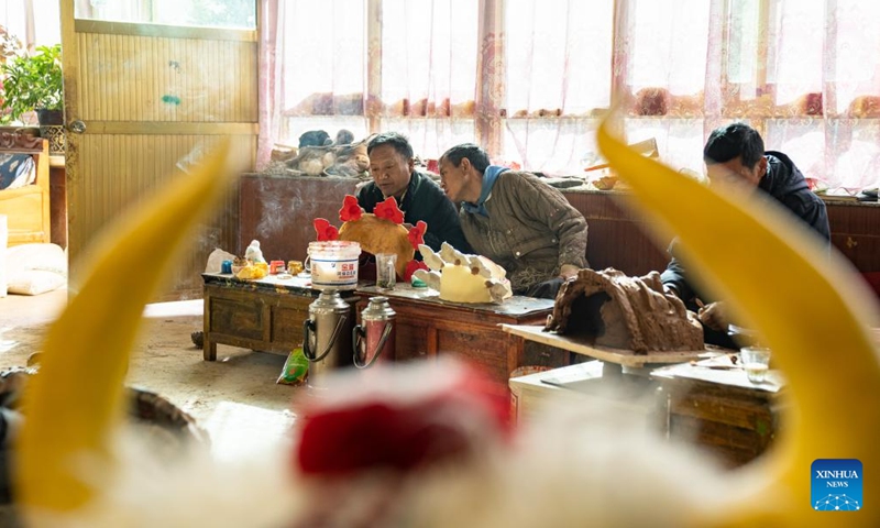 Shilok (1st L) and his colleague talk about traditional Tibetan mask-making experience in Lhasa, southwest China's Xizang Autonomous Region, Dec. 9, 2024. (Photo: Xinhua)