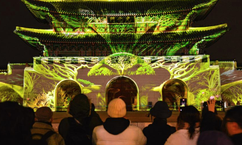 People take pictures of the light show during 2024 Seoul Winter Festa in front of Gwanghwamun in Seoul, South Korea, Dec. 16, 2024. This ongoing event will last until January 5, 2025. (Xinhua/Xu Qin)