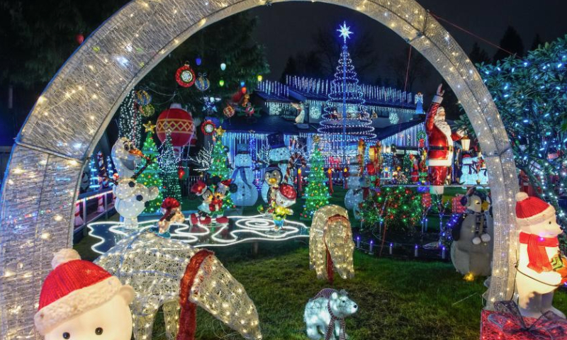 Christmas lights and decorations are seen in the front yard of a residential house in Vancouver, British Columbia, Canada, Dec. 22, 2024. (Photo by Liang Sen/Xinhua)