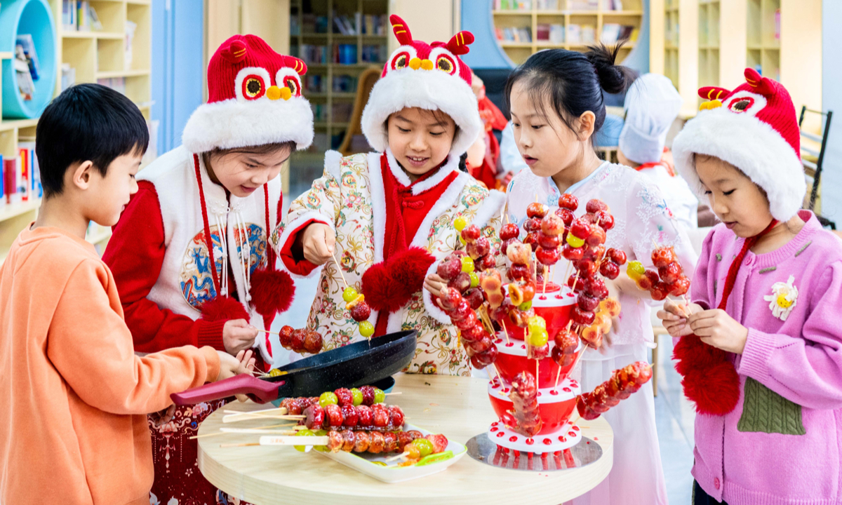 Primary school students learn how to craft sugar-coated haws in Hohhot, North China's Inner Mongolia Autonomous Region, Dec. 19, 2024. Photo: VCG