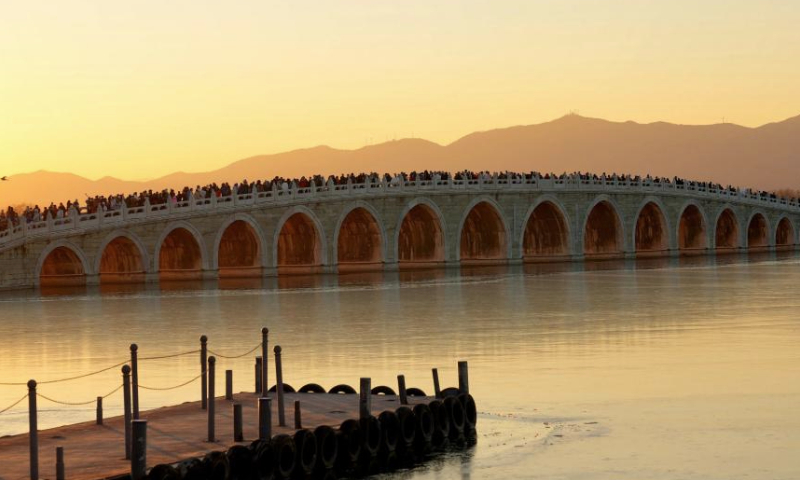 People visit the 17-Arch Bridge in the Summer Palace in Beijing, capital of China on Dec. 22, 2024. (Xinhua/Xing Guangli)