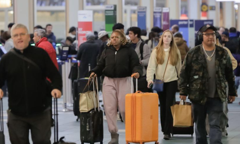 Travelers are seen at the Vancouver International Airport in Richmond, British Columbia, Canada, Dec. 21, 2024. With Christmas just around the corner, Vancouver International Airport is preparing for its busiest travel season. (Photo by Liang Sen/Xinhua)