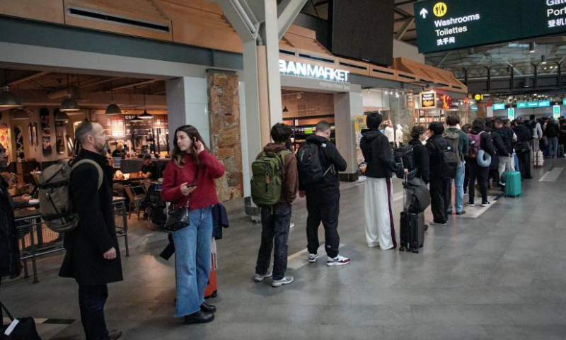 Travelers wait in line to pass through security check at the Vancouver International Airport in Richmond, British Columbia, Canada, Dec. 21, 2024. With Christmas just around the corner, Vancouver International Airport is preparing for its busiest travel season. (Photo by Liang Sen/Xinhua)