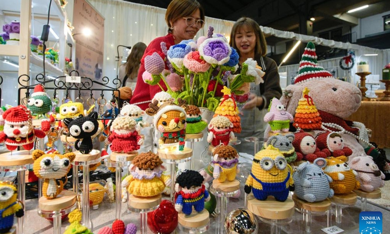 People look at various handmade ornaments on display during the annual Make It Show in Vancouver, British Columbia, Canada, Dec. 12, 2024. The annual event showcases a diverse array of handmade goods from over 250 artists, makers and craftsmen. (Photo by Liang Sen/Xinhua)